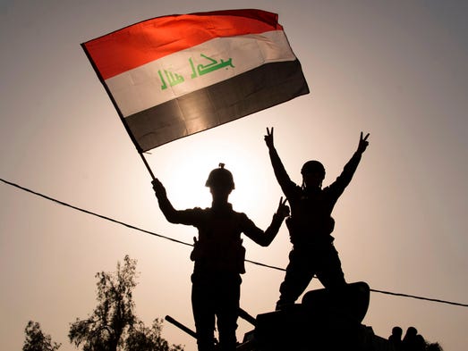 Iraq's federal police members wave Iraq's national
