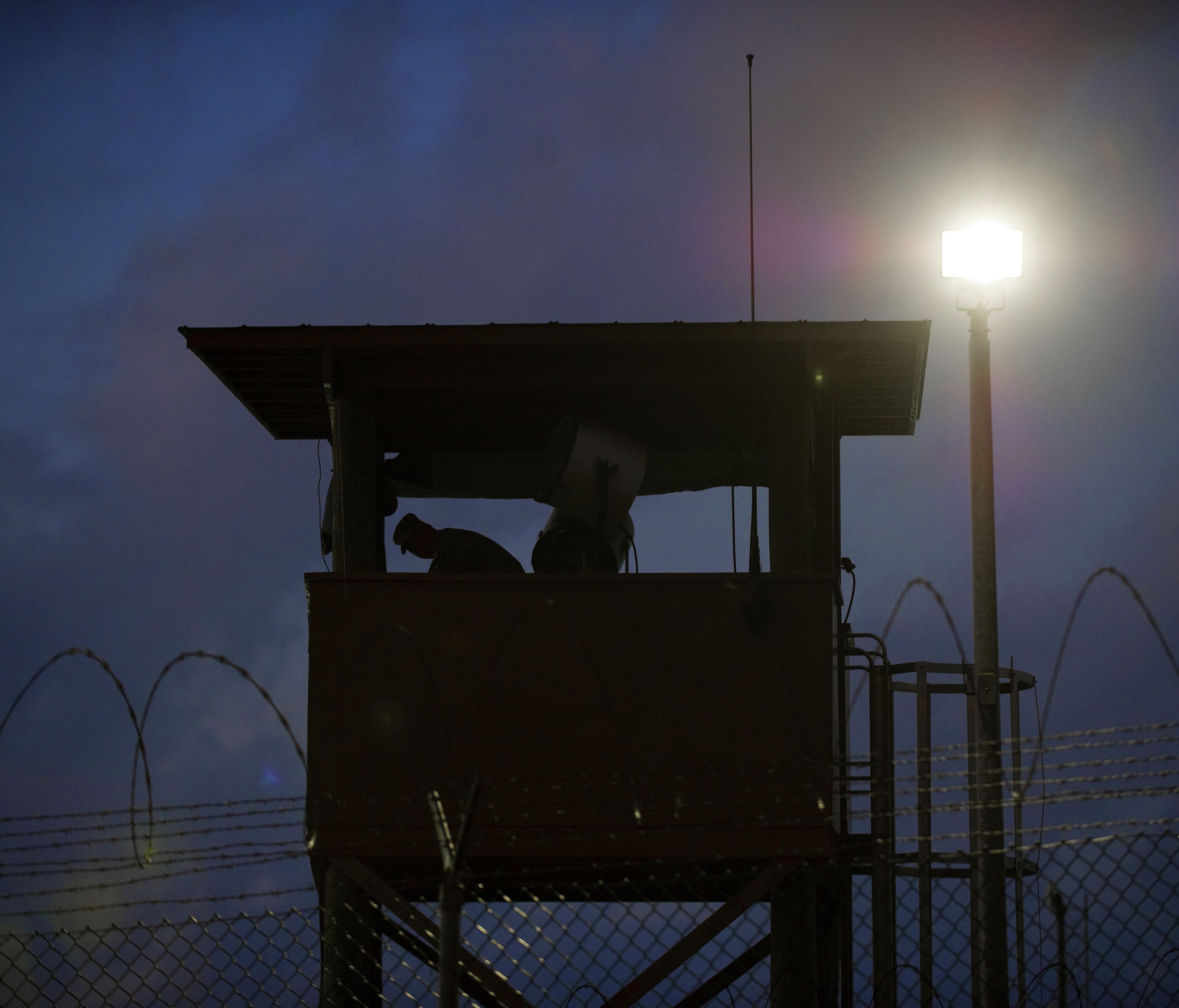In this March 30, 2010 file photo reviewed by U.S. military officials, a member of the U.S. military mans the guard post before sunrise at Camp Delta, part of the U.S. Detention Center in Guantanamo Bay, Cuba.