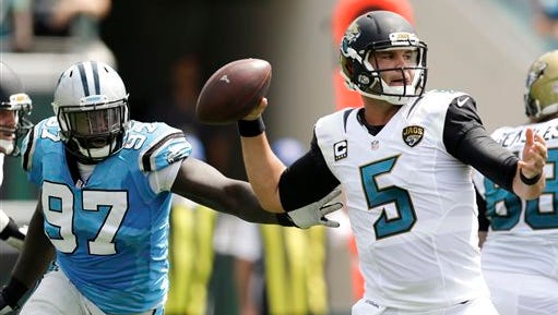 Jacksonville Jaguars quarterback Blake Bortles (5) looks for a receiver as Carolina Panthers defensive end Mario Addison (97) puts on pressure during the first half of an NFL football game in Jacksonville, Fla., Sunday, Sept. 13, 2015. (AP Photo/John Raoux)