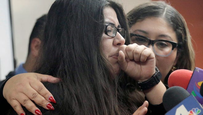 Marlene Mosqueda, left, whose father was arrested by ICE early Friday to be deported, is comforted at a news conference by her attorney Karla Navarrette at the Coalition for Humane Immigrant Rights of Los Angeles. Navarrete said she sought to stop Mosqueda from being placed on a bus to Mexico and was told by Immigration and Customs Enforcement agents that things had changed. She said another lawyer filed federal court papers to halt his removal.