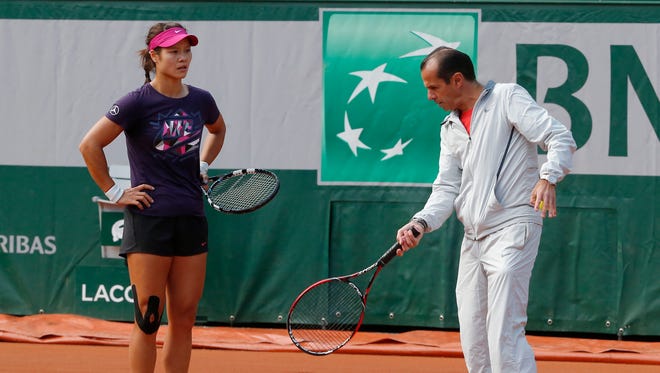 Li Na listens to the advice of former coach Carlos Rodriguez during a training session for the French Open in 2014.