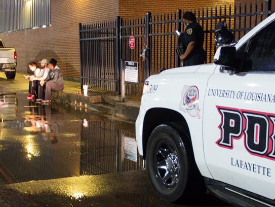 A UL police officer stands guard as Ragin Cajun softball players wait to get into their locked locker room.