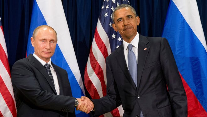 In this 2015 file photo, U.S. President Barack Obama, right, and Russia's President President Vladimir Putin pose for members of the media before a bilateral meeting at the United Nations headquarters. President Barack Obama is promising that the U.S. will retaliate against Russia for its suspected meddling in America's election process, an accusation the Kremlin has vehemently denied.