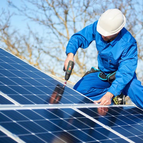 An electrician works on solar panels.