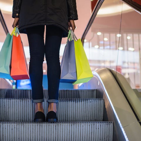 A shopper holding different bags while riding up o