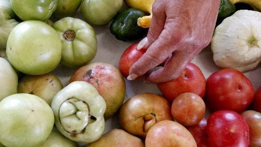 A customer picks out produce at the Anderson County Farmers Market. A voucher program allows seniors in the county to get free produce from area farmers markets.