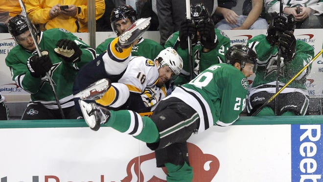 Predators right wing James Neal (18) is shoved over the railing into the bench by Stars defenseman Stephen Johns (28) during the first period Tuesday.