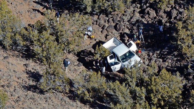 Crime scene investigators work the scene around the white pickup Tuesday, Jan. 10, 2017, on the Santa Ana Pueblo, New Mexico where the bodies of two women and three children were found.