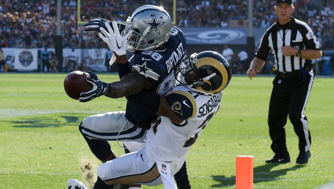 Dallas Cowboys wide receiver Dez Bryant (88) scores a touchdown defended by Los Angeles Rams defensive back Coty Sensabaugh (21) during the first quarter at Los Angeles Memorial Coliseum.