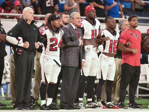 Falcons owner Arthur Blank stands with players during