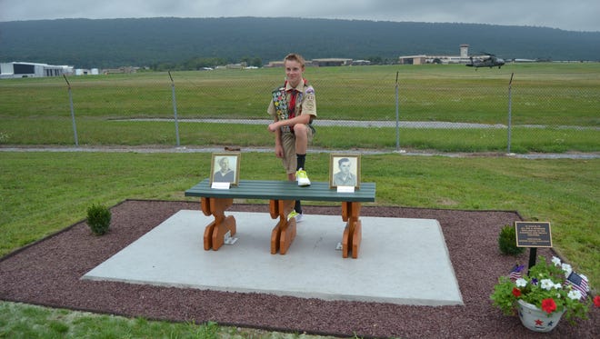 Boy Scout Zachary Herzog poses with a memorial that he designed and built to honor veterans at Fort Indiantown Gap.