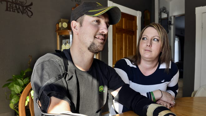Jamie Houdek, with his wife, Lisa, at his side, talks about his recovery after he lost his right hand to a corn picker in November 2013 on the 60-acre hobby farm where he raises beef cattle.