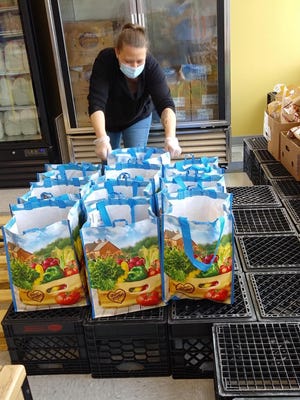 A Malden YMCA volunteer pre-packs groceries to serve the over 300 households that come to the Mystic Community Market each day. All Malden YMCA led and supported market sites are pre-packing bags for safety. 