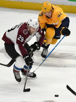 Colorado Avalanche center Nathan MacKinnon (29) moves the puck as Nashville Predators center Ryan Johansen (92) reaches for a steal during the second period in game 5 of the first round NHL Stanley Cup Playoffs at the Bridgestone Arena Friday, April 20, 2018, in Nashville, Tenn.
