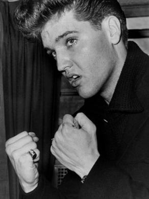 Elvis Presley, dressed in civilian clothes, after his return home from the army March 7, 1960. Elvis was greeted by a crowd of some 200 people in the early morning cold at Memphis' Union Station. In the afternoon, he held a press conference in the two-room office building behind Graceland where he explained to newsmen the use of karate, a form of judo. Presley became a student of karate while stationed in Germany.