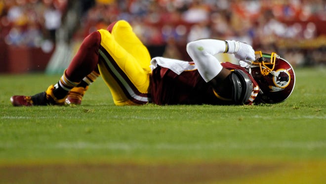 Washington Redskins quarterback Robert Griffin III (10) lies on the ground after being hit against the Detroit Lions in the first quarter at FedEx Field.