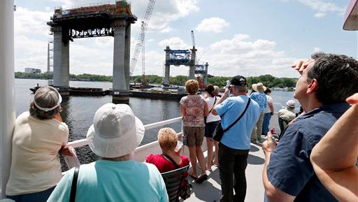 In this July 22, 2015 photo, people on the top deck of a river boat view piers toward the Minnesota side for the mile-long St. Croix Crossing bridge linking Minnesota and Wisconsin near Stillwater, Minn. Three times a month, 350 or more people head out on the 90-minute tours, with adults paying $10 apiece for the chance to view one of the biggest and most expensive bridge projects in Minnesota history. (AP Photo/Jim Mone)