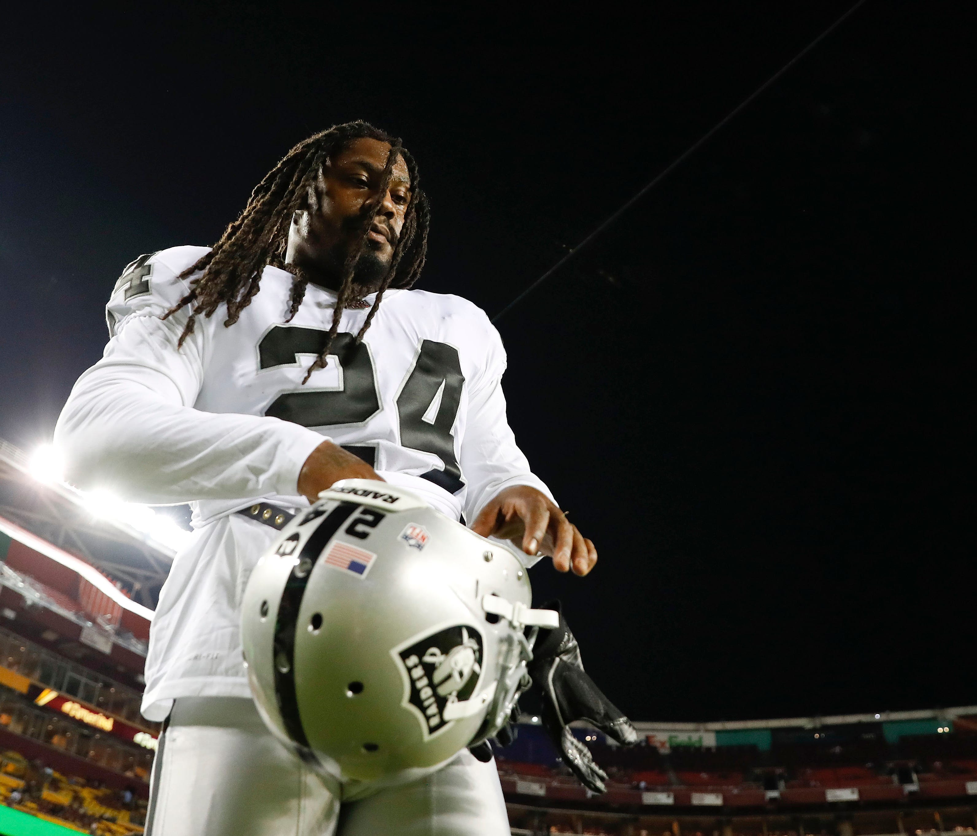Oakland Raiders running back Marshawn Lynch (24) puts on his helmet before an NFL football game against the Washington Redskins in Landover, Md., Sunday, Sept. 24, 2017. (AP Photo/Alex Brandon) ORG XMIT: NYOTK137