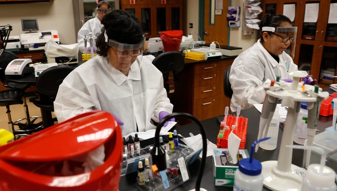 Lucinda Begay, left, and Neldra Castillo participate in a lab Friday during class at San Juan College in Farmington.