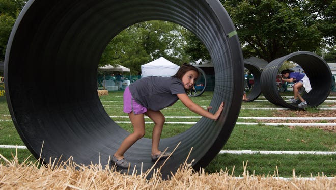 Kayleigh Krebs , 7, of Pocomoke City, Md., plays on the tire tumblers at the 12th annual Fifer's Fall Fest in Wyoming.