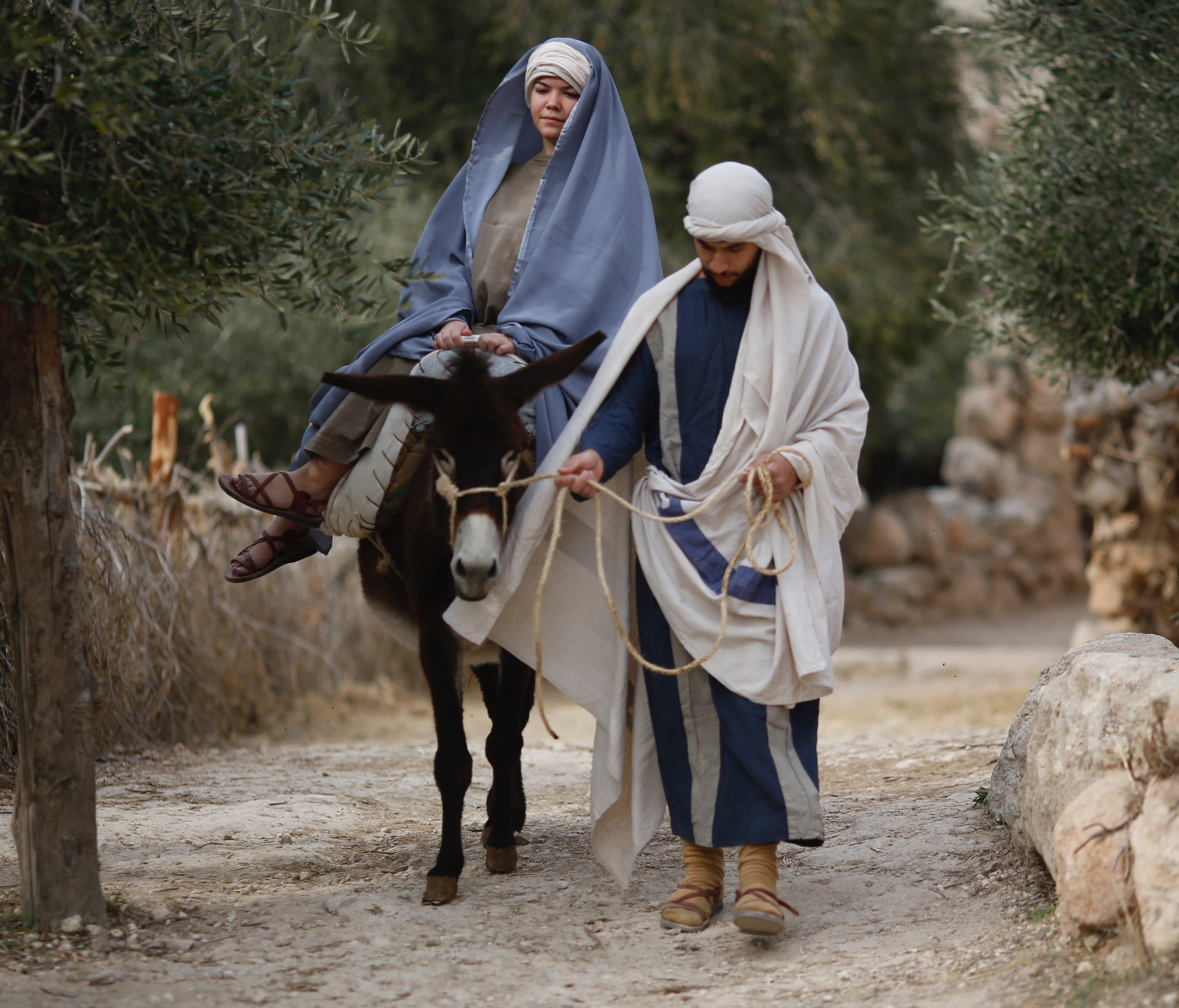 Christian actors portray Joseph and Mary during a re-enactment of a Nativity scene of the journey to Bethlehem as part of Christmas festivities at the Nazareth Village, northern Israel, Thursday, Dec. 21, 2017.