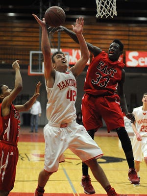 Green Bay East junior Deonte Carlton blocks the shot of Manitowoc Lincoln’s Ben Kohls during a 2014 game in Manitowoc.