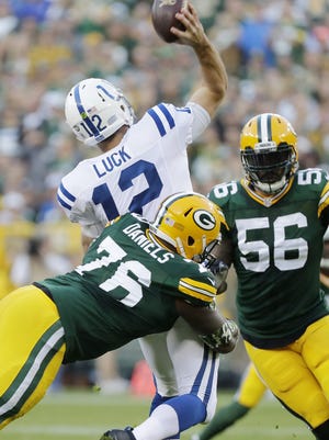 Green Bay Packers defensive end Mike Daniels (76) hits Indianapolis Colts quarterback Andrew Luck (12) as he throws at Lambeau Field.