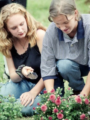 West High School students Brandy Pack, left, and Jaime Horrocks prepare flowers for planting in the front of their school in September 1996.