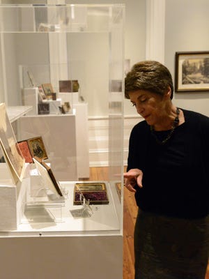 Judith Oppenheimer, external relations manager for the Decorative Arts Center of Ohio, points out a photograph in the museum's new exhibit Wednesday, Sept. 13, 2017, in Lancaster.