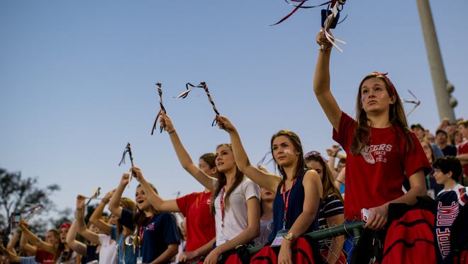 Notre Dame students wave streamers and cheer during an LHSAA football game against Teurlings Catholic in Crowley, La., Friday, Sept. 18, 2015. 