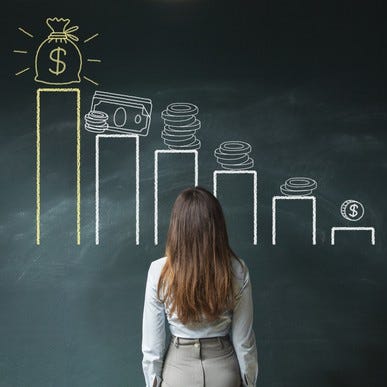 Girl staring at chalkboard, which has a bar graph with money symbols above each bar.