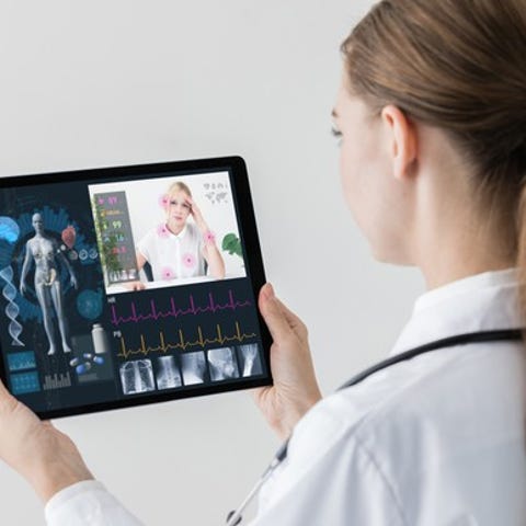 A female doctor holding a tablet and having a virt