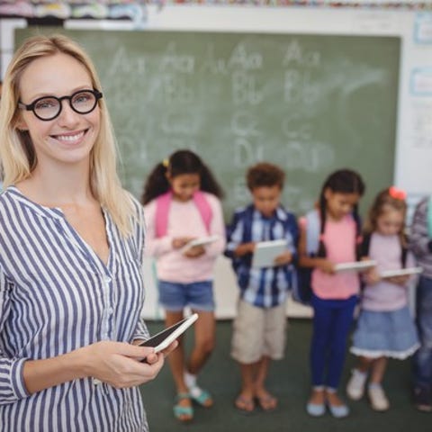 school teacher standing in front of students and...