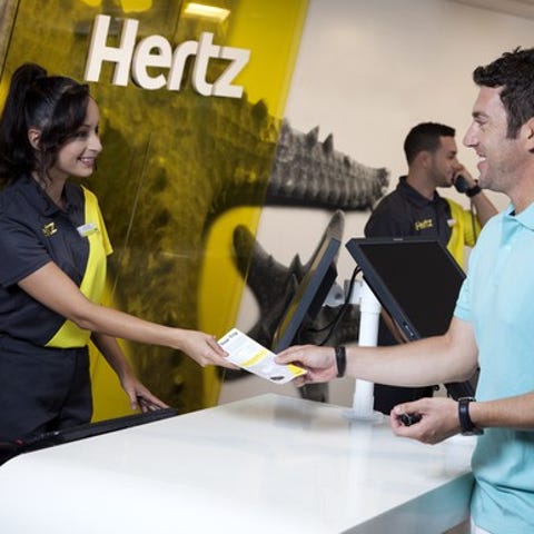 Hertz counter with employee handing rental agreeme