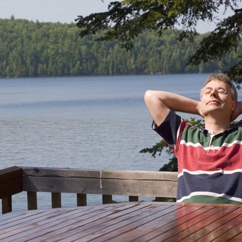 Middle-aged man relaxing by a lake.