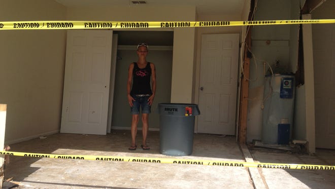 Krystle Day stands inside the gaping hole in her home on Fifth Ave. A green Fort Explorer crashed into the house early Monday morning.