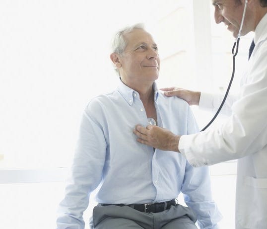 Doctor examining senior male patient.