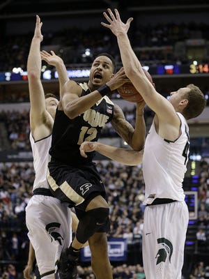 Purdue Boilermakers forward Vince Edwards (12) drives between Michigan State Spartans forward Matt Costello (10),left, and Colby Wollenman (41) in the first half of their Big Ten Men's Basketball Tournament championship game Sunday, Mar 13, 2016, afternoon at Bankers Life Fieldhouse.