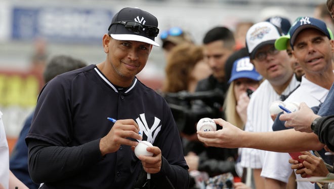 Yankees' Alex Rodriguez signs autographs for fans during a workout.