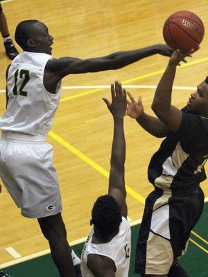 Gallatin's Zool Kueth gets a hand on the shot of Mt. Juliet's Tony Thompson during Tuesday's game.
