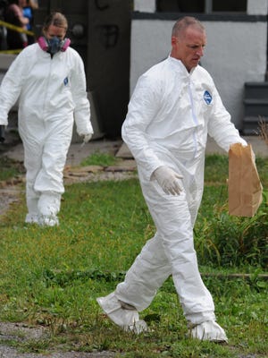David Horn and Brenda McNeely of the Ohio BCI collect evidence from 218 West Mansfield Street in Bucyrus were a dead body was found Tuesday.