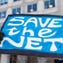 A woman holds a 'Save the Net' protest sign during a demonstration against the proposed repeal of net neutrality outside the Federal Communications Commission headquarters  in Washington, DC on December 13, 2017.