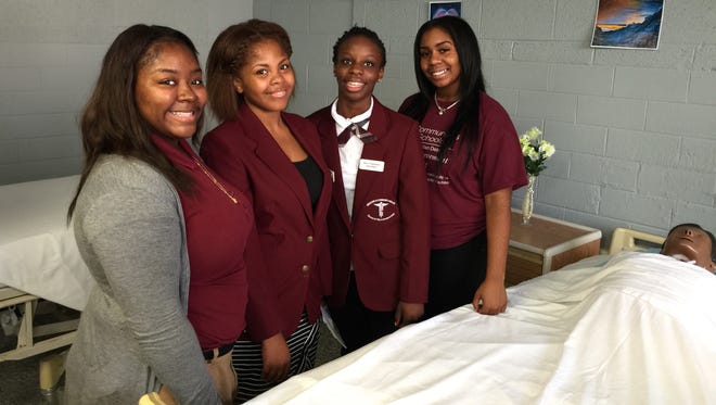 Students, from left, Shanteer Simmons, 17, Latayah McClane, 17,  Shakayla Johnson, 16, and Lanita Lesley, 16, are enrolled in a program to train to become firefighters and EMTs by the time they graduate from high school.