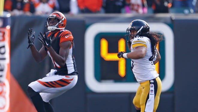 Cincinnati Bengals wide receiver A.J. Green (18) hauls in a long pass as he is defended by Pittsburgh Steelers strong safety Troy Polamalu (43) during the second quarter of their game played at Paul Brown Stadium in Cincinnati, Ohio Sunday December  7, 2014. The play set-up the Bengals first Touchdown. The Enquirer/Gary Landers