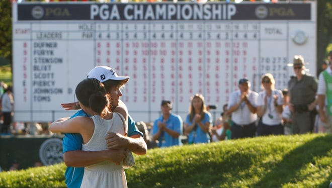 Jason Dufner hugs wife on the 18th green following his two stroke victory at the final round of the 95th PGA Championship Sunday, Aug. 11, 2013 at Oak Hill Country Club in Pittsford.