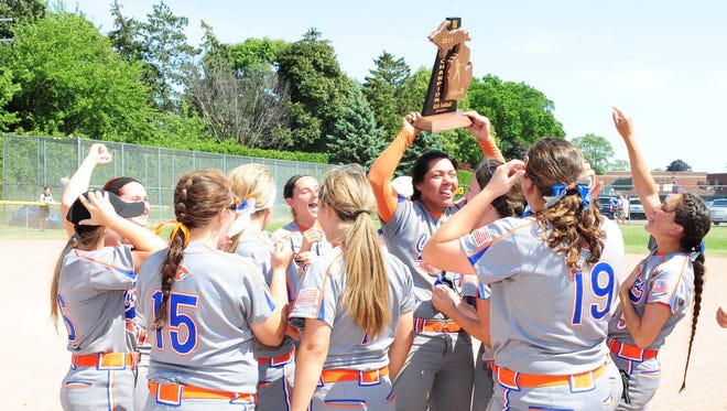 Garden City softball hero Alicia Ascencio holds up the Division 1 regional trophy during the Cougars' celebration Saturday at Grosse Pointe South.