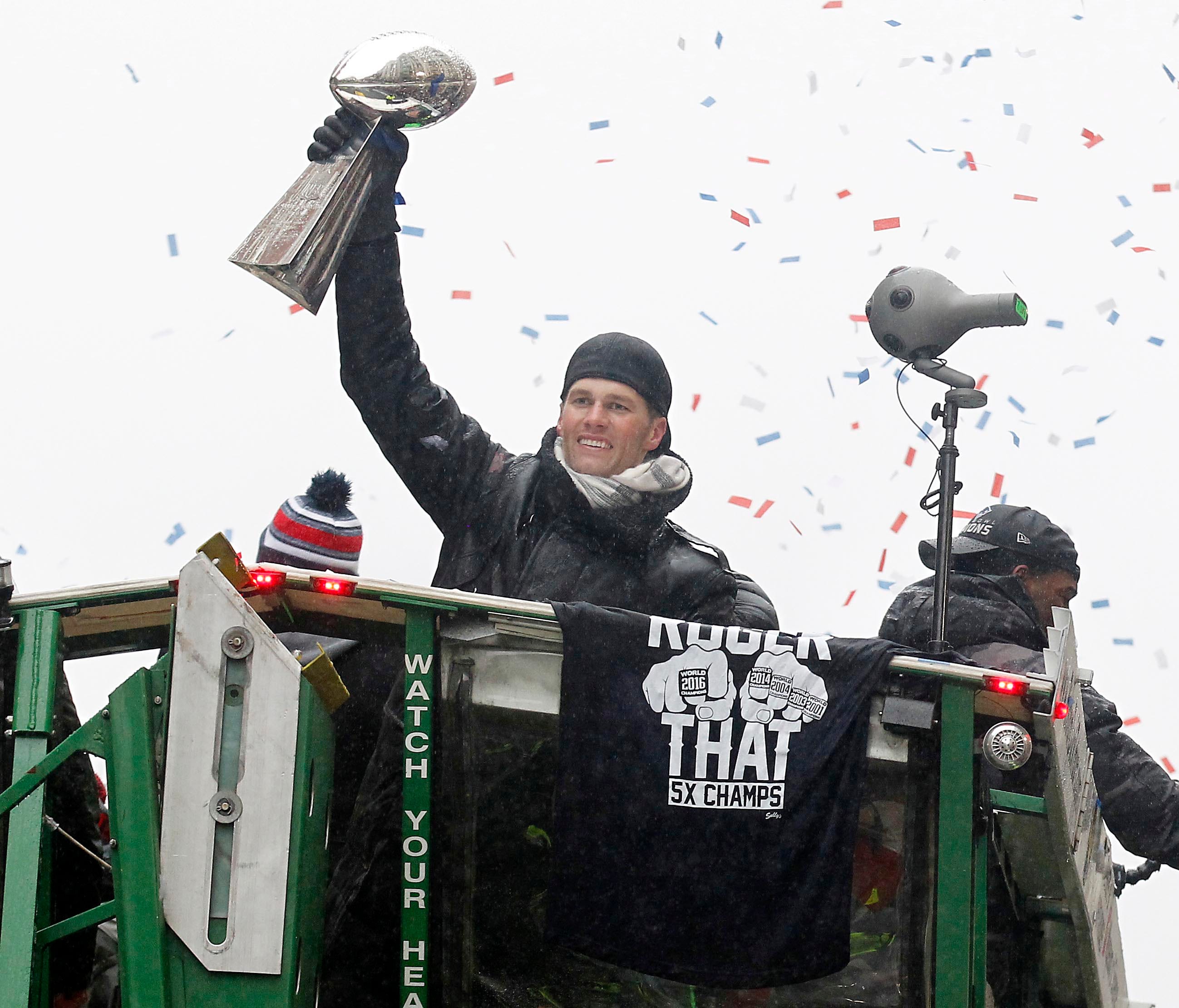 New England Patriots quarterback Tom Brady hoists the Lombardi Trophy as he rides a duck boat during the Super Bowl LI parade.