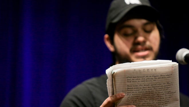 Xavier Cuevas, also known as BarelyHispanic, recites a poem handwritten inside his notebook inside the Poetry Room at the Robin Theatre on February 27th, 2018.