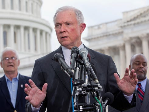 Sen. Jeff Sessions, R-Ala., discusses immigration in June. Behind him are Hans Marsen, left, an immigrant from England, and Niger Innis with TheTeaParty.net.