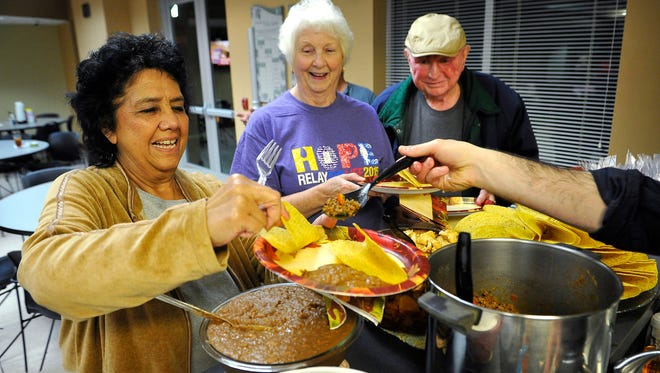Wally Jones gets help making her tacos as she and Wanda and Paul Crider prepare to sit down for a meal together in the dining room at the American Cancer Society's Memorial Foundation Hope Lodge in Nashville, The lodge has offered a temporary housing solution since 2004 to cancer patients who must undergo treatment far from home.